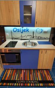 a kitchen with a sink and a sign that says oasis at Design Apartments Red Blue in Osijek