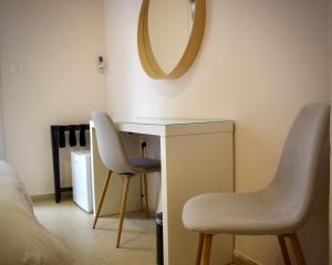 a bedroom with a desk and two chairs and a mirror at B12 Inn in Jerusalem