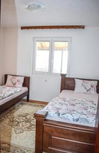 a bedroom with two beds and a window at Ema Guest House in Plav