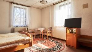 ノイウハウゼンにあるPension Grenzhofのベッドルーム(ベッド1台、薄型テレビ付)