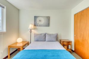 ein Schlafzimmer mit einem Bett mit blauen Laken und zwei Tischen in der Unterkunft Bayview Cottage in Barview