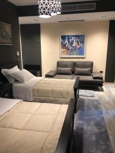 1 dormitorio con 2 camas y sofá en Dream's Hotel, en Gjirokastra