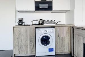 a washing machine under a counter in a kitchen at Great studio with a sea view and parking in 400 meters from Monaco in Beausoleil