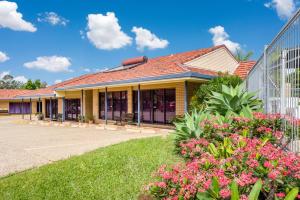 a house with flowers in front of a building at Aspley Carsel Motor Inn in Brisbane