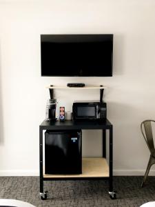 a black table with a television on a wall at The Nomad Motel - International Falls, MN - Near Canadian Border in International Falls