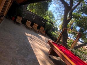 a row of benches in a park with a tree at Casa Aura Beachfront B&B in Tamarindo