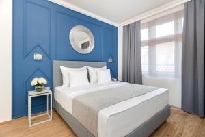a blue bedroom with a large bed and a mirror at Eight Secrets Boutique Residence in Prague