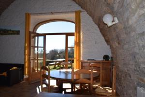 comedor con mesa y ventana en Gîte du Dolmen de l'Hom, en Le Massegros