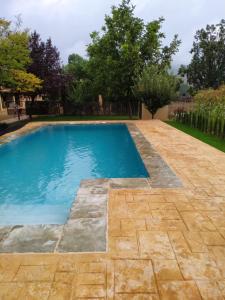 een zwembad in een tuin met een stenen patio bij Casas Rurales Majana in Riópar