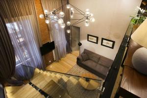 Paskunji Residence في تبليسي: غرفة معيشة مع أريكة وثريا