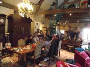 un grupo de personas sentadas alrededor de una mesa en una habitación en Chambre d'hôtes Le Vaujoint en Cheillé