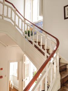 a white staircase with wooden railings in a house at Casa Londres in Estoril