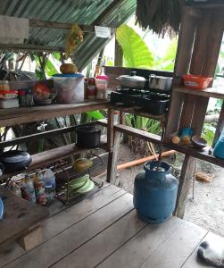 eine Küche mit einem Tisch mit Töpfen und Pfannen in der Unterkunft Xingú Camping Site in Leticia