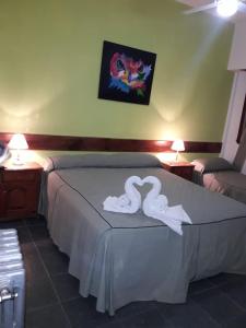 een slaapkamer met 2 witte zwanen op een bed bij Hotel Las 40 in Villa Gesell