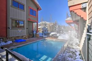 a swimming pool in the snow next to a house at Mtn Chic Frisco Condo Large Deck and Stunning View! in Frisco