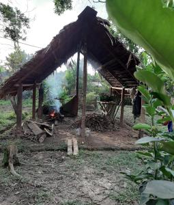 a hut with a fire in front of it at Xingú Camping Site in Leticia