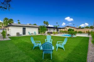 een tuin met stoelen en een tafel en een huis bij Peaceful Palms Permit# 4341 in Palm Springs