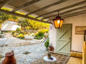 a patio with a green door and a lamp at Casa Rico Frade Garden in São Pedro do Corval +26 photos
