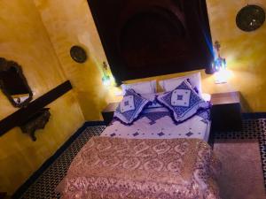 1 dormitorio con 1 cama con almohadas azules en Riad Safari Fes en Fez