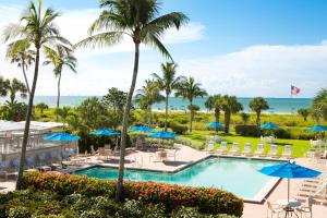 a view of the pool at the resort with chairs and umbrellas at Sanibel Inn in Sanibel