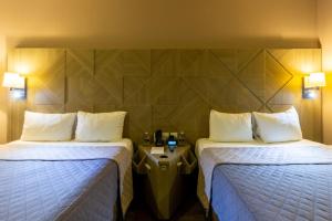 Un pat sau paturi într-o cameră la Hotel Glow Point - Mulza