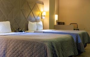Un pat sau paturi într-o cameră la Hotel Glow Point - Mulza