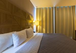 Un pat sau paturi într-o cameră la Hotel Glow Point - Mulza