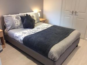 Una cama o camas en una habitación de Spacious ground floor studio flat - easy access to Stansted Airport, London and Cambridge