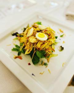 um prato branco com uma salada com ovos em VIVERONE LAKE ROOMS em Viverone