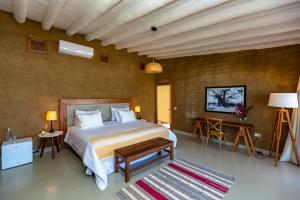 um quarto com uma cama, uma mesa e um tapete em Adobe Villas em Máncora