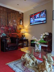 sala de estar con TV en la pared en The New Guilderoy Hotel, en Blackpool
