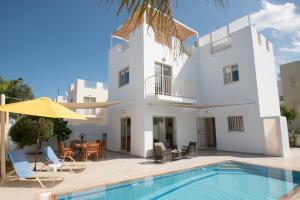 a villa with a swimming pool and a house at Villa Pomelo in Protaras
