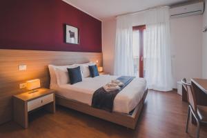 una camera con un grande letto e una parete rossa di Trip Room & Breakfast a Reggio di Calabria