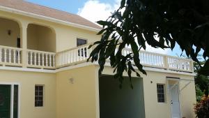 a house with a balcony on top of it at Manuae House of Birds 1 in Cliftons