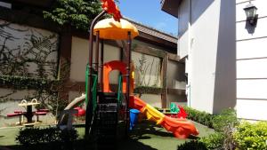 een speeltuin met een glijbaan in een tuin bij StayPlus Metro Manila Solano Hills Tropical Home Suite in Manilla