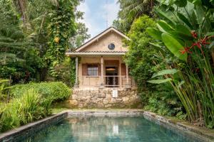 a house with a swimming pool in front of a house at Villa Sunset Jogjakarta in Yogyakarta