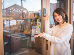a woman standing in front of a door at 4S STAY Awaikeda Ekimae in Miyoshi