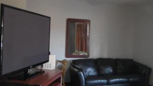 a living room with a black leather couch and a flat screen tv at Laurel Inn in Oakland +16 photos