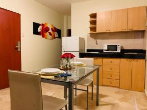 a kitchen with a table with chairs and a microwave at San Francisco Apart Hotel in Guayaquil