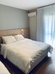 una camera da letto con un grande letto bianco e una finestra di Apart nos jardins a San Paolo