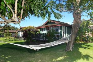 a hammock in front of a house at Nona Lani Cottages in Kihei