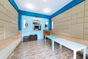 een bankje in een kamer met blauwe muren bij RedDoorz Premium @ Casa Ghilda Resort Olongapo City in Olongapo