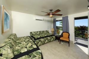 a living room with a couch and a ceiling fan at Nona Lani Cottages in Kihei