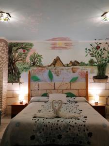 una camera da letto con un letto con due cigni sopra di Alojamientos Turísticos Centro de Extremadura a Calamonte