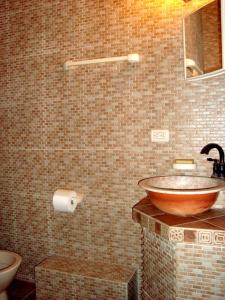 a bathroom with a bowl sink and a toilet at Casa La Guaria in Sámara