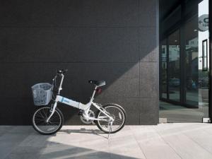 a bike with a basket parked next to a building at Kindness Day Hotel in Tainan