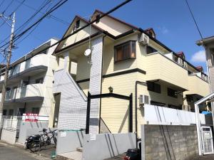 a yellow house on a street at THE MICKEY CARLTON Ohashi 206 in Shiobaru