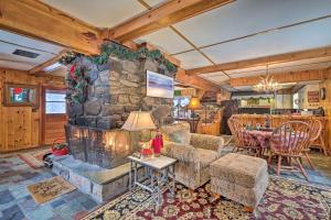 a living room with a stone fireplace and a table at Bolton Alderbrook Lodge with Private 10-Acre Lake! in Bolton