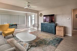 a living room with a couch and a tv at Bright Bungalow with Porch Walk to Ormond Beach! in Ormond Beach