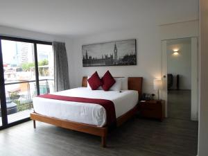 a bedroom with a large bed and a large window at Armonik Suites in Mexico City